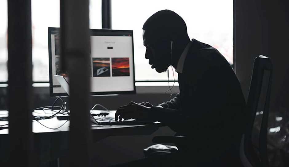 man at his computer in a silhouette